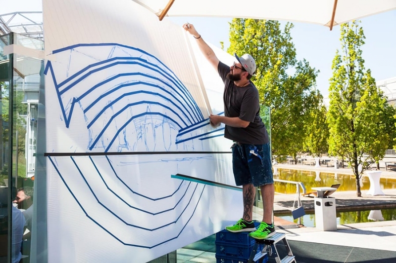 Slava klebt das großes Kunstwerk-Live Tape Art show für Leipziger Messe
