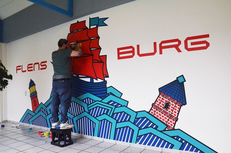 Flensburg- Kleben an der Wand- Tape Graffiti Auftrag- Künstler bei der Arbeit