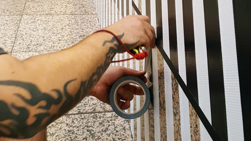 Ostap-Tape-Artist beim Kleben-Die Hände-Nahaufnahme