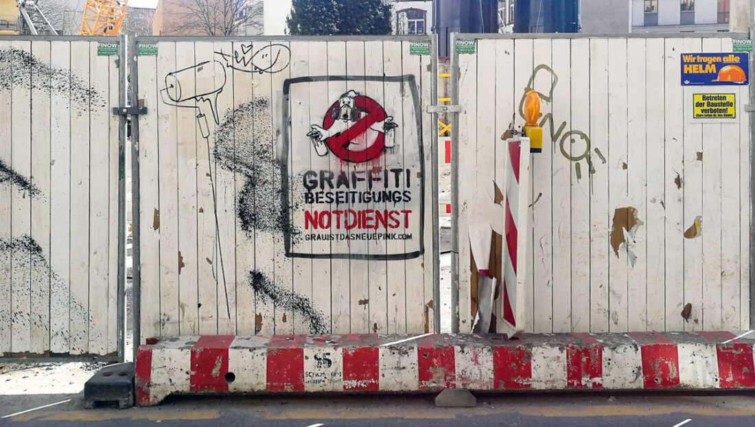 Stencil street art on a construction fence