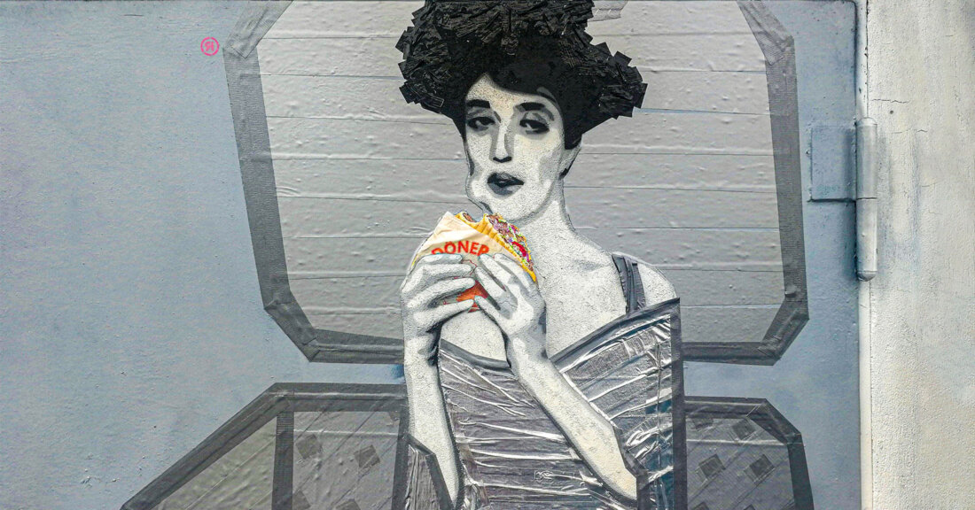 Street art character holding a döner on a concrete wall